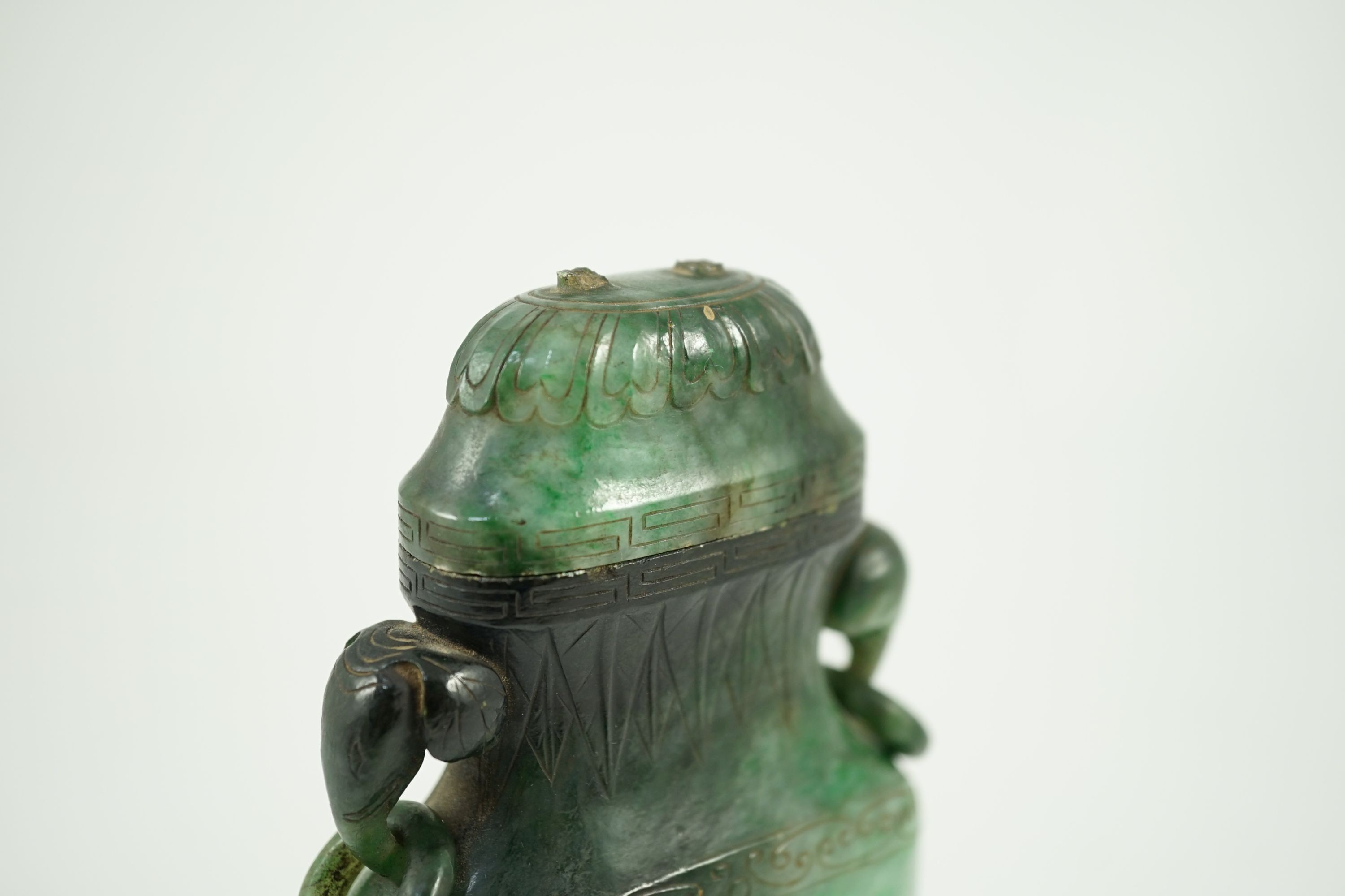 A Chinese archaistic green jadeite vase and cover, late Qing dynasty, 14.5 cm high, Silver wire inlaid wood stand, cover finial missing